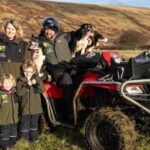 farmer callum Lindsay with his wife and two young daughters, and sheepdog, next to an ATV on the Isle of Arran